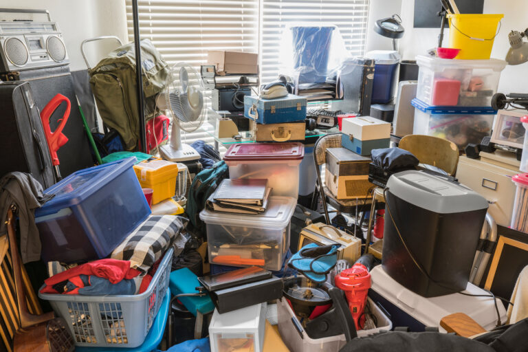 Hoarder room packed with boxes, electronics, business equipment, household objects and miscellaneous junk.